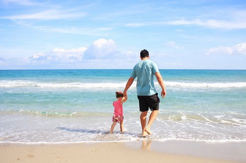 Father and child enjoying the surf in Bermuda - Budget Bermuda Travel Guide